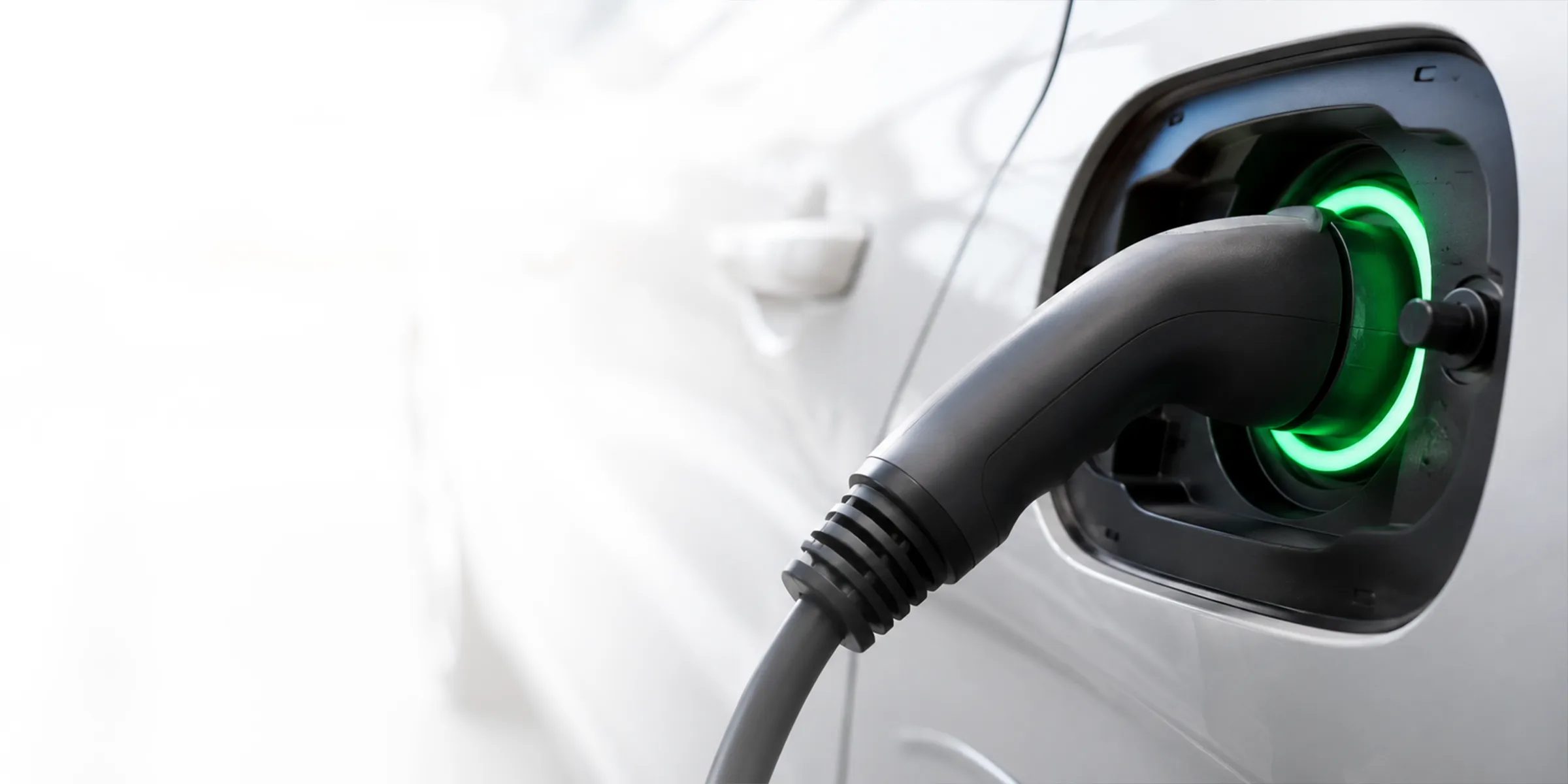 Ladestecker in der Ladebuchse eines Elektroautos, Verriegelungsring leuchtet grün – E-Auto-Service in Wien Meidling