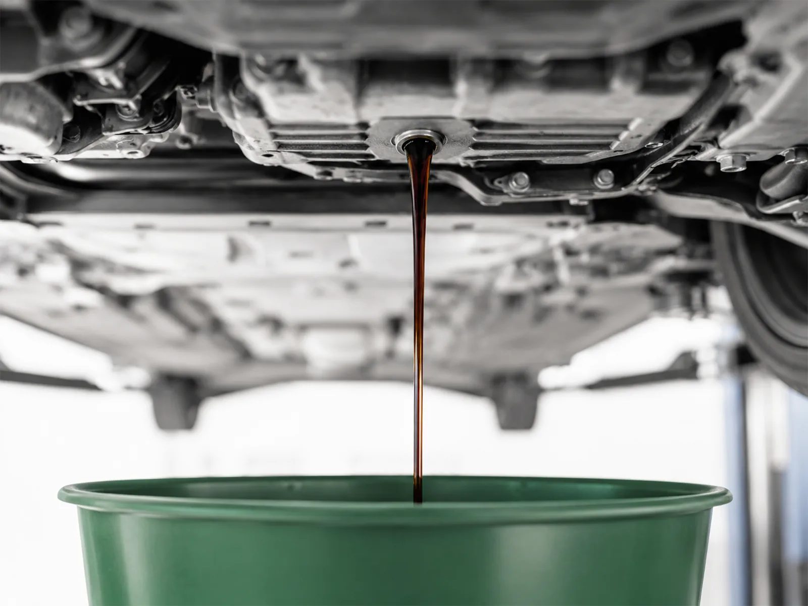 Altöl läuft aus der Ölablassschraube in die Auffangwanne – Ölwechsel bei My Car Service in Wien Meidling